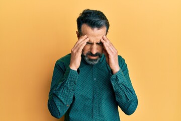 Middle age man with beard and grey hair wearing business clothes with hand on head for pain in head...
