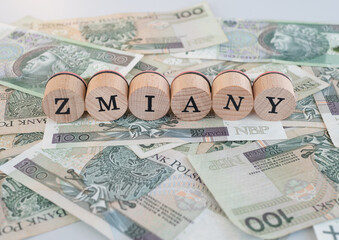 Word "zmiany" written in polish with wooden blocks standing on money, "zmiany" means "changes"