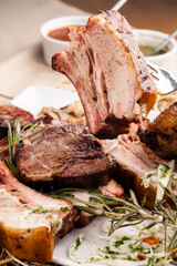 Grilled pork ribs with rosemary and sauces.  Pork ribs BBQ.  The large plate of meat.  Roast pork