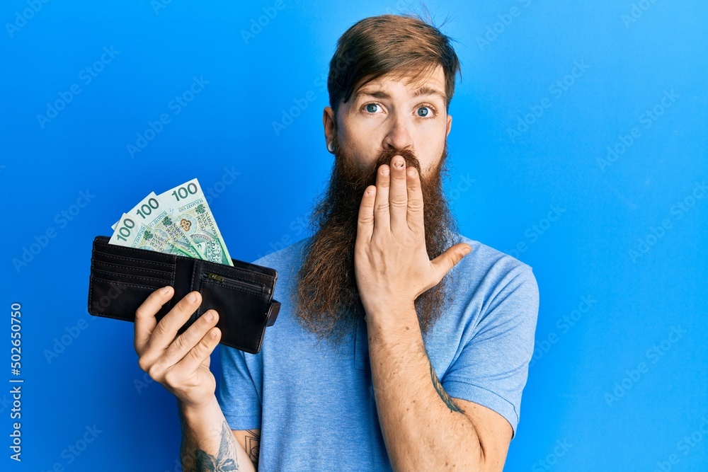 Canvas Prints redhead man with long beard holding wallet with polish zloty banknotes covering mouth with hand, sho