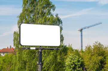 Blank white billboard for advertisement in front of the construction site near city park
