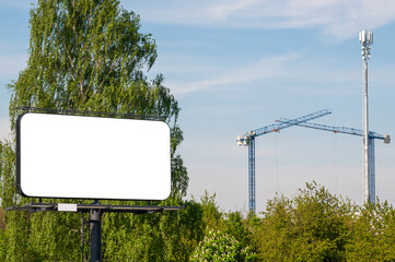 Blank white billboard for advertisement in front of the construction site near city park
