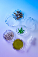 Abstract cosmetic laboratory in neon light of cannabis research. Blue and purple duotone. Natural cosmetics or super food. Legal and Medical use of marijuana. Top view.