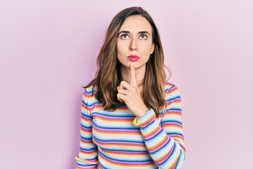 Young hispanic girl wearing casual clothes thinking concentrated about doubt with finger on chin and looking up wondering