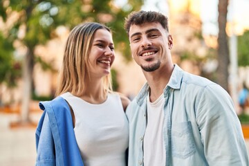 Fototapeta premium Young man and woman couple smiling confident standing together at street