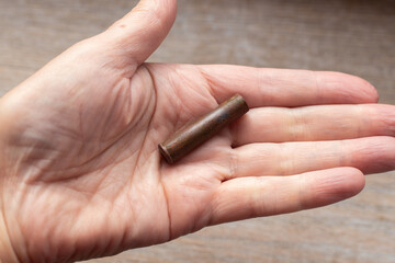 A cartridge case from an old Nagan revolver cartridge in the palm of your hand. War finds of the early 20th century