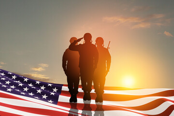 USA army soldiers saluting with nation flag on a background of sunset or sunrise. Greeting card for...
