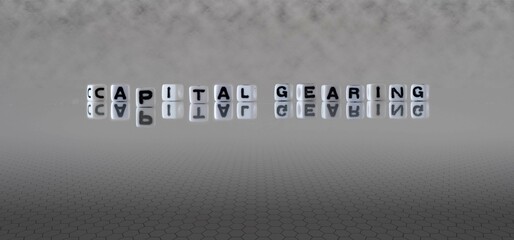 capital gearing word or concept represented by black and white letter cubes on a grey horizon background stretching to infinity