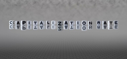 capitalization rate word or concept represented by black and white letter cubes on a grey horizon...