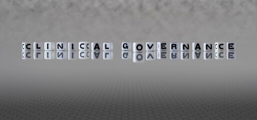 clinical governance word or concept represented by black and white letter cubes on a grey horizon...
