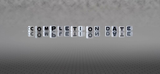 completion date word or concept represented by black and white letter cubes on a grey horizon...
