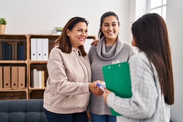 Three woman patient and psychologist shake hands at psychology center