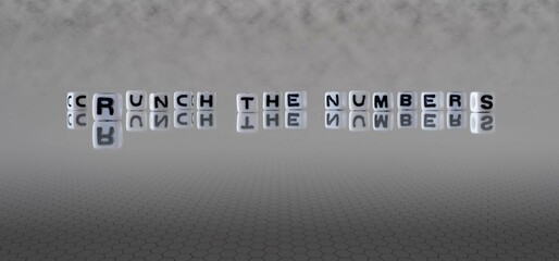 crunch the numbers word or concept represented by black and white letter cubes on a grey horizon...