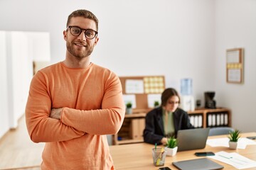 Obraz premium Businessman smiling happy with arms crossed gesture standing at the office.