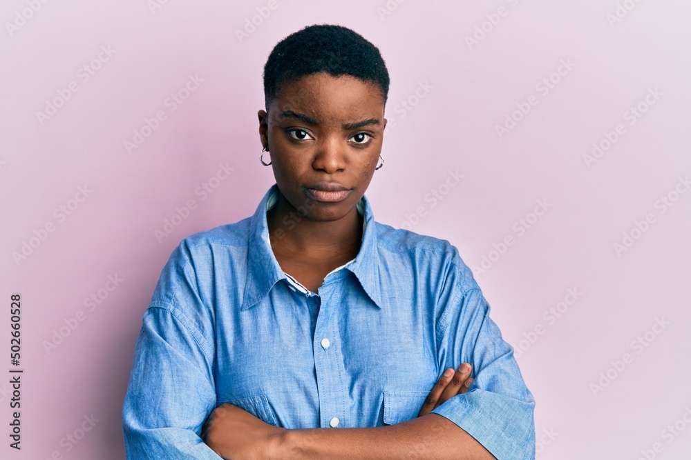 Wall mural Young african american woman wearing casual clothes skeptic and nervous, disapproving expression on face with crossed arms. negative person.