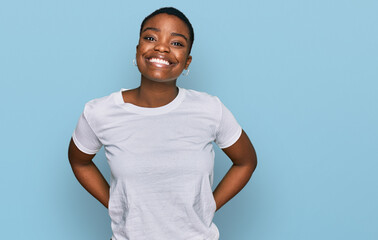 Young african american woman wearing casual white t shirt with a happy and cool smile on face....