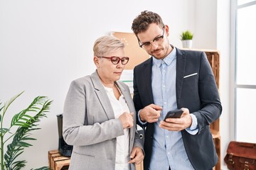 Mother and son business workers using smartphone at office