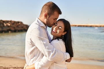 Obraz premium Man and woman couple smiling happy hugging each other standing at seaside