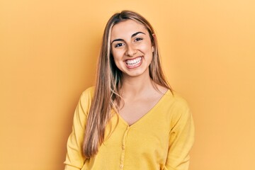 Beautiful hispanic woman wearing casual yellow sweater with a happy and cool smile on face. lucky person.
