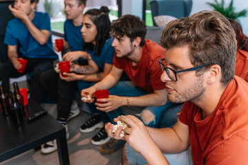 friends looking expectant to the possible victory of their sports team. group watching a movie or...