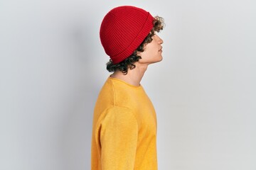 Handsome young man wearing wool hat looking to side, relax profile pose with natural face with...