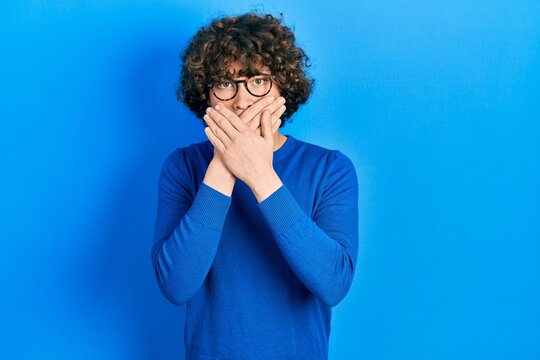 Handsome young man wearing casual clothes and glasses shocked covering mouth with hands for mistake. secret concept.