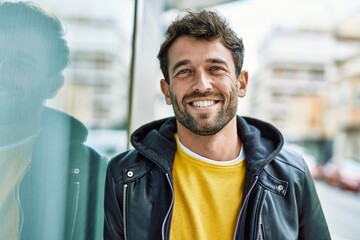 Handsome hispanic man with beard smiling happy outdoors