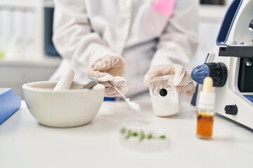 Young chinese woman wearing scientist uniform working at laboratory