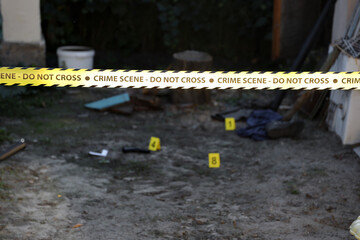 Crime scene tape for covering the area cordon. Yellow tape with blurred forensic law enforcement...