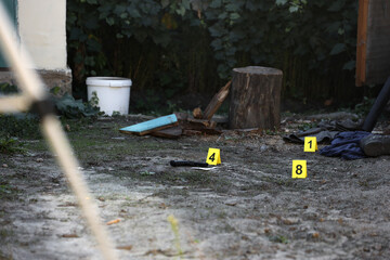 Evidence with yellow CSI marker for evidence numbering on the residental backyard in evening. Crime...