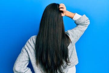 Obraz premium Young hispanic woman wearing casual clothes backwards thinking about doubt with hand on head