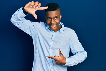 Young african american man wearing casual clothes smiling making frame with hands and fingers with happy face. creativity and photography concept.