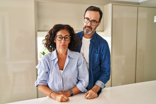 Middle age couple standing together looking sleepy and tired, exhausted for fatigue and hangover, lazy eyes in the morning.