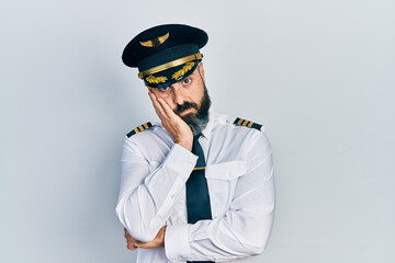 Young hispanic man wearing airplane pilot uniform thinking looking tired and bored with depression...