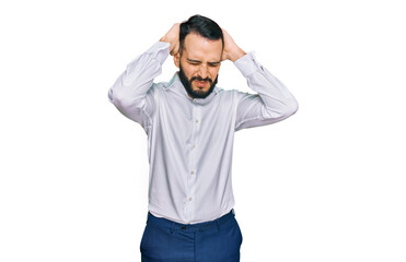 Young man with beard wearing business shirt suffering from headache desperate and stressed because pain and migraine. hands on head.
