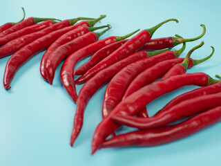 Chili peppers isolated on blue background. Red hot chili peppers as an ingredient of Asian and...