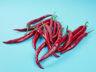 Chili peppers isolated on blue background. Red hot chili peppers as an ingredient of Asian and Mexican cuisine and spices