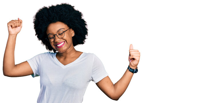 Young african american woman wearing casual white t shirt dancing happy and cheerful, smiling moving casual and confident listening to music