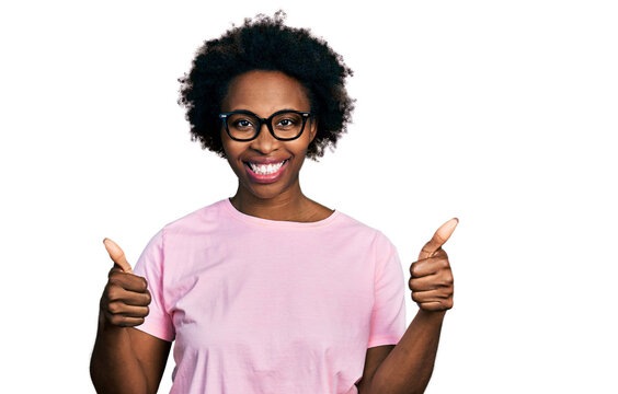 African american woman with afro hair wearing casual clothes and glasses success sign doing positive gesture with hand, thumbs up smiling and happy. cheerful expression and winner gesture.
