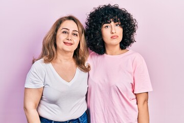 Middle east mother and daughter wearing casual clothes relaxed with serious expression on face. simple and natural looking at the camera.