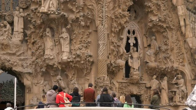 Group of tourists admire the entrance of the Sagrada Familia in Barcelona, Spain. High quality 4k footage