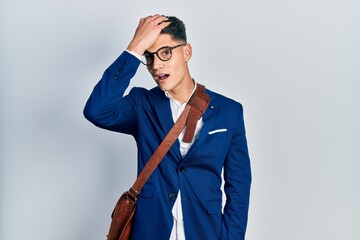 Young hispanic man wearing business clothes surprised with hand on head for mistake, remember...