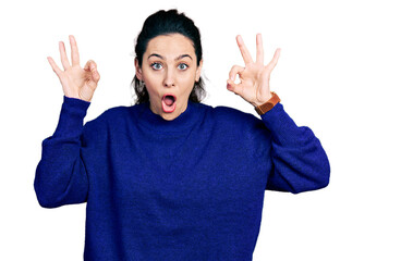 Fototapeta premium Young hispanic woman wearing casual clothes looking surprised and shocked doing ok approval symbol with fingers. crazy expression