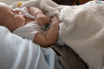 Latin baby sleeping in daddy arms