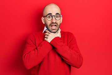 Fototapeta premium Young bald man wearing casual clothes and glasses shouting and suffocate because painful strangle. health problem. asphyxiate and suicide concept.