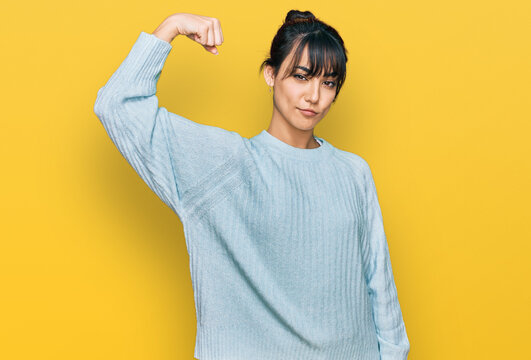 Young hispanic woman wearing casual clothes strong person showing arm muscle, confident and proud of power