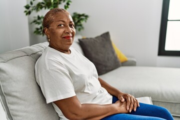 Senior african american woman smiling confident sitting on sofa at home