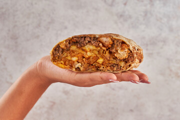 mano sosteniendo un burrito mexicano