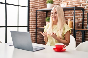 Young blonde woman having video call using deaf language at home