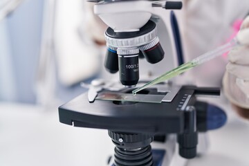 Young woman scientist using microscope working at laboratory